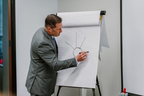 A Rmada United instructor writing on a large pad of paper with a a sharpie