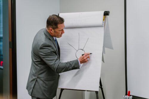 A Rmada United instructor writing on a large pad of paper with a a sharpie